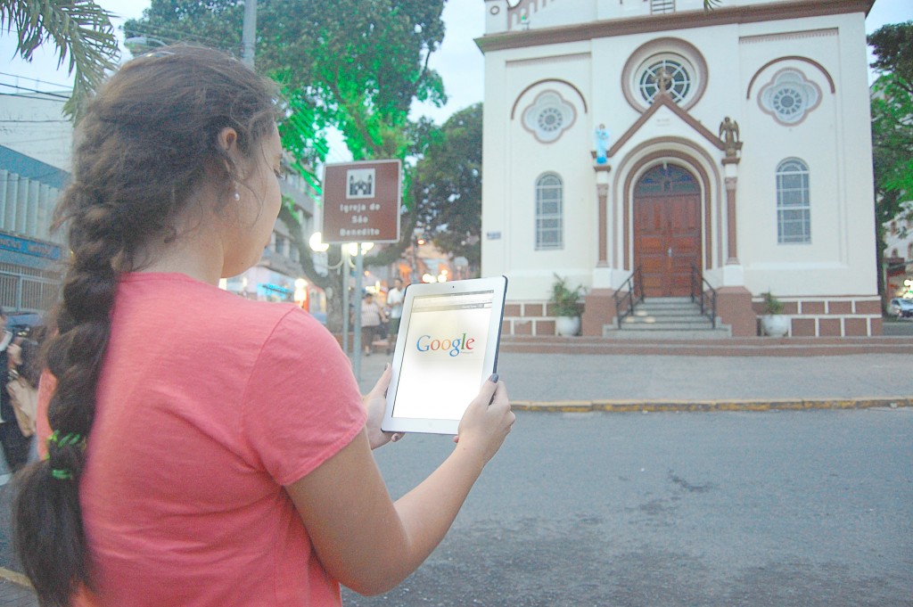 Moça confere tablet em plena praça central da cidade, onde os roubos dos aparelhos são frequentes (Arquivo Atos)