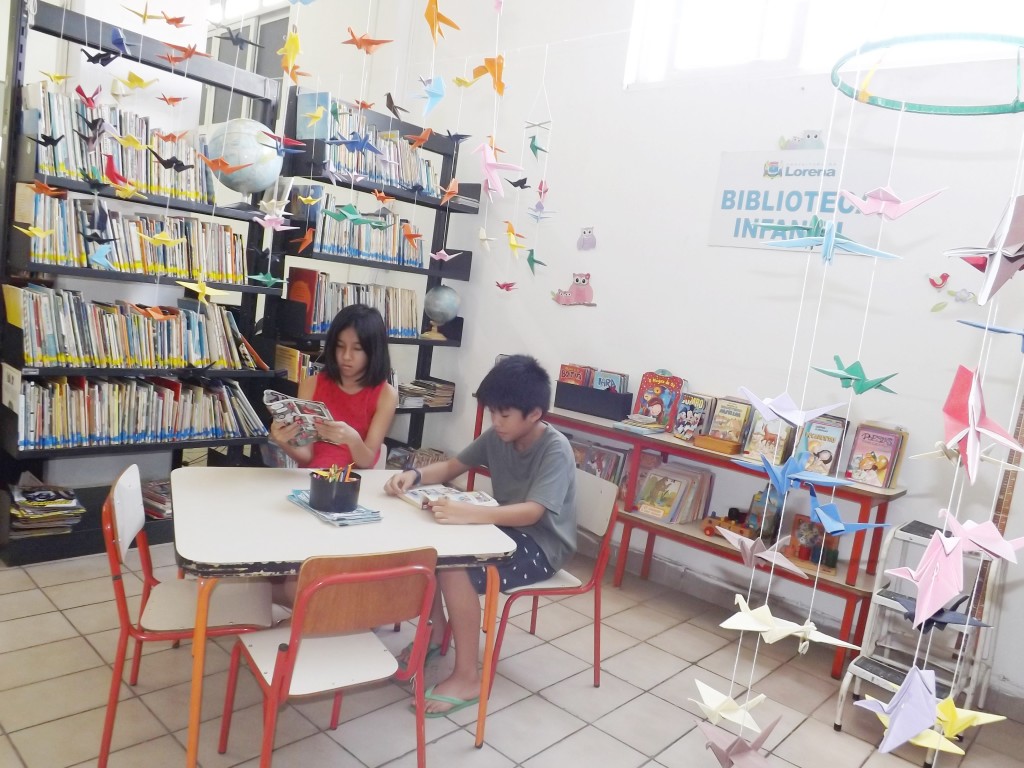 Crianças leem revistas em área destinada ao público infantil; na era da informação, Biblioteca de Lorena ganhou destaque com aumento de público nos últimos três anos (Rafaela Lourenço)