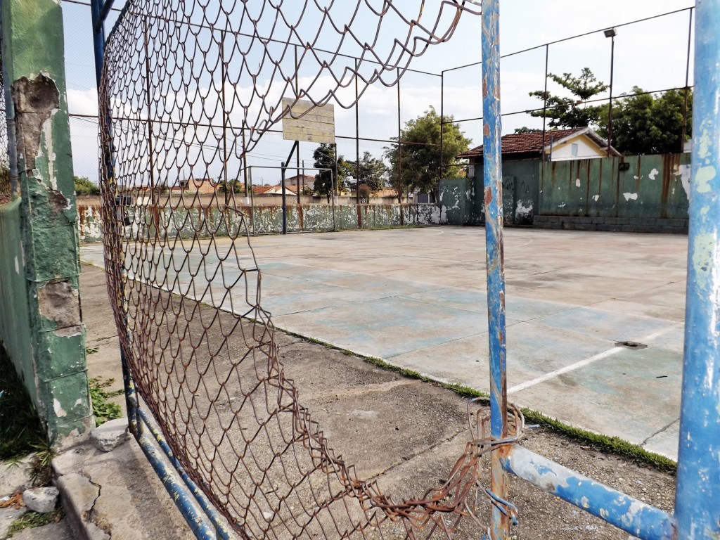 Alambrado destruído, tabelas de basquete sem aro, piso com irregularidades; cenário mostra abandono de quadra esportiva em Cachoeira (Foto: Lucas Barbosa)