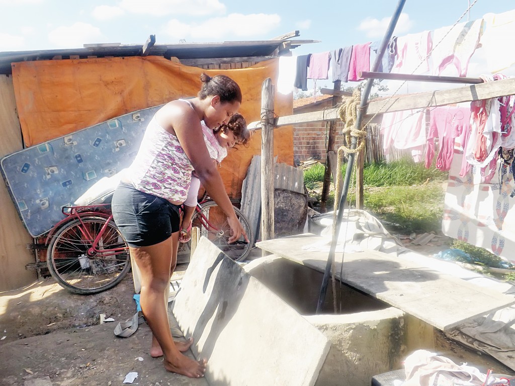 Moradora mostra poço de água improvisado; bairro terá tratamento (Foto: Arquivo Atos)