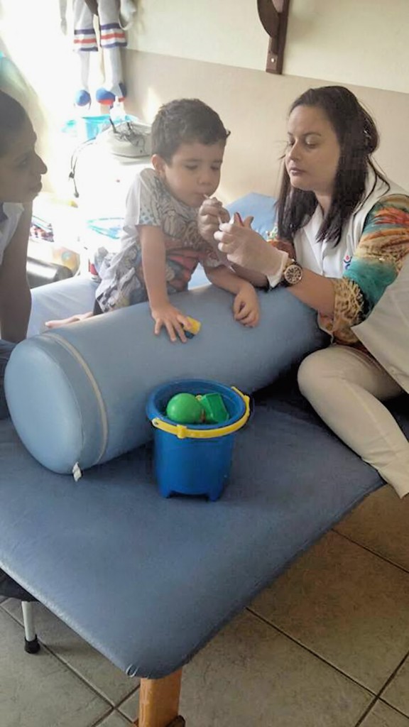 O pequeno Bruno, de quatro anos, faz sessão com fonoaudióloga; mãe luta por apoio para vencer doença (Foto: Reprodução)